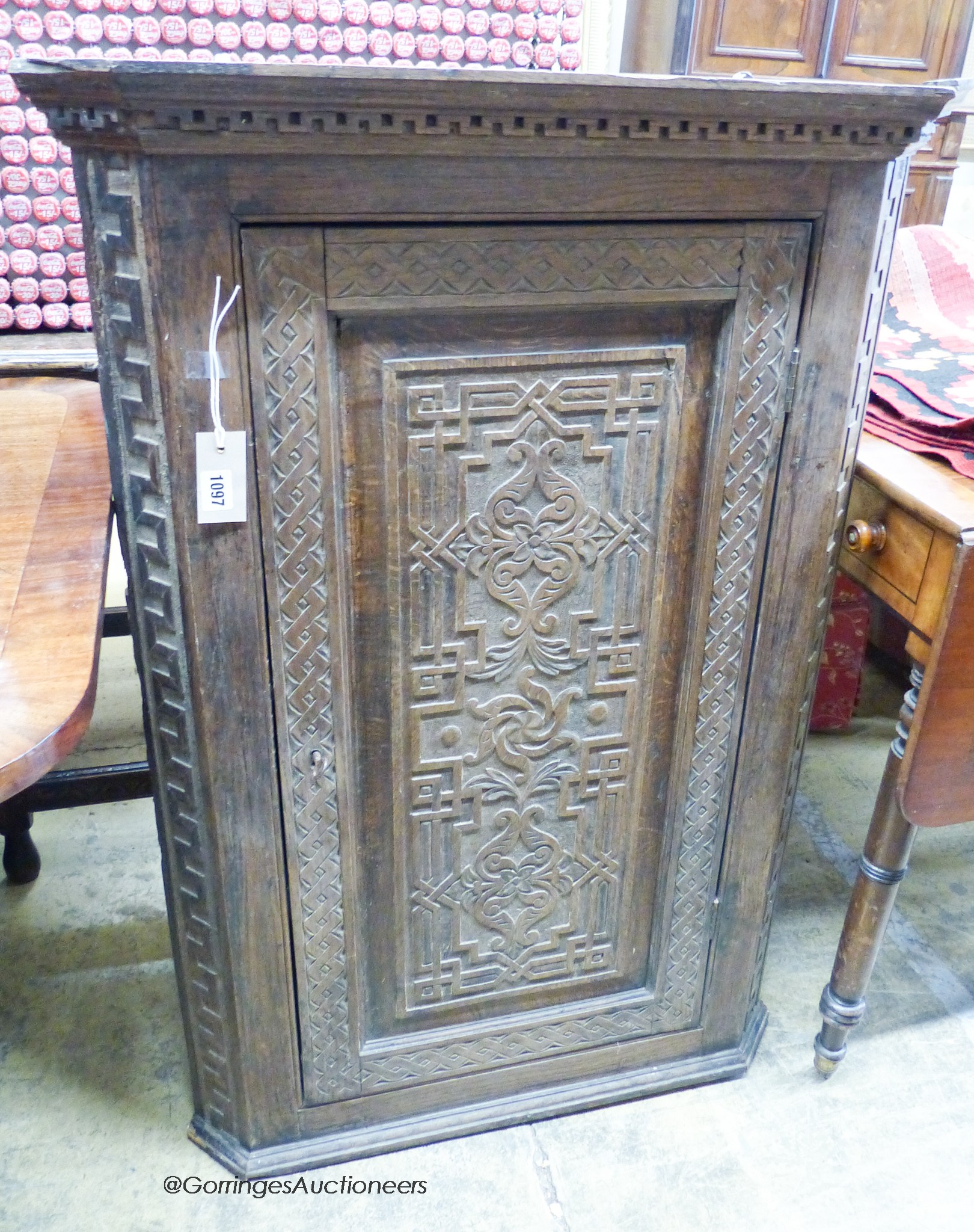 A carved oak hanging corner cupboard, width 70cm, depth 42cm, height 106cm